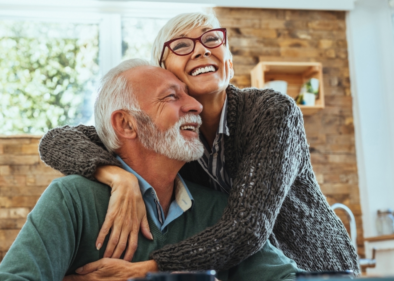 mature couple hugging at kitchen table