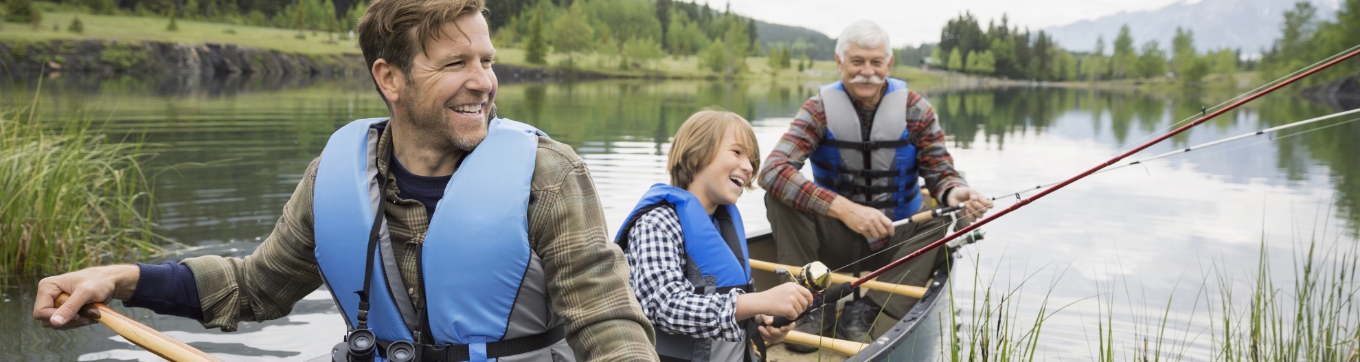 three generations of men fishing in a canoe