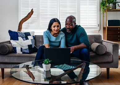 Older couple on couch looking at laptop