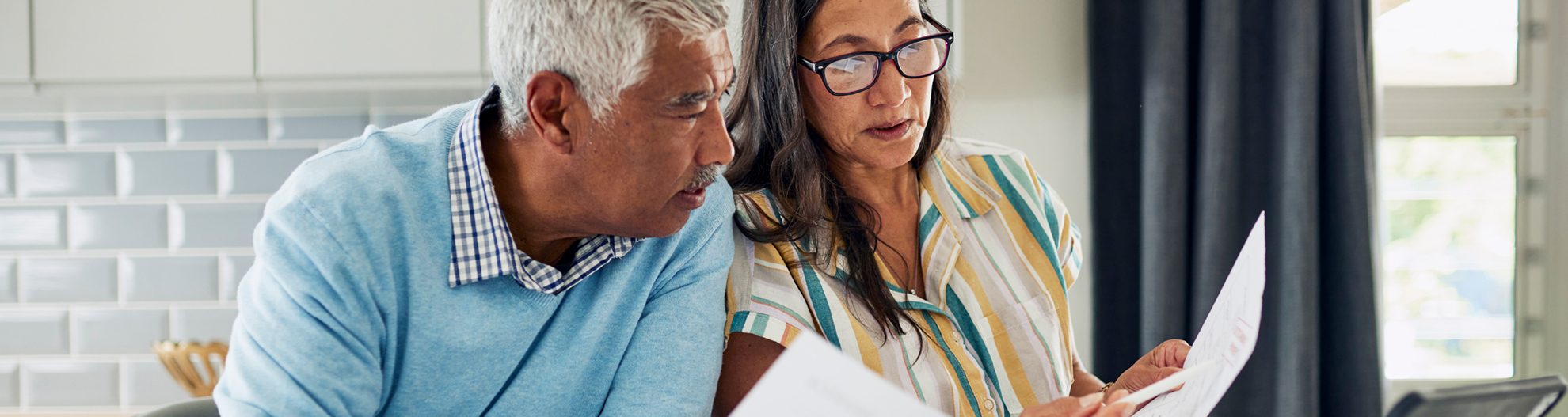 Couple reviewing documents at kitchen table